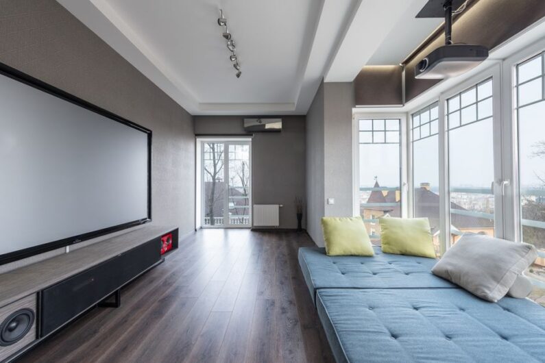 Moderne cinewall in een stijlvolle woonkamer met een grote tv en sfeervolle verlichting.