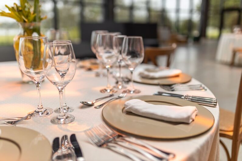 Een grote houten eettafel voor 10 personen in een sfeervol ingerichte eetkamer met moderne stoelen.
