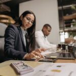 Een ondernemer die een zakelijke rekening opent en zijn financiën beheert met een laptop en notitieboek.